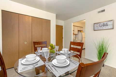 a dining room with a glass table and chairs